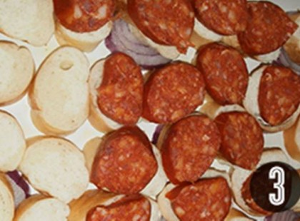 Karikára vágott kiflit és kolbászt rak egy tepsi aljára, majd elkészíti a világ legkülönlegesebb rántottáját!