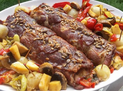 A tarját tedd alufóliára, kend meg mustárral és töltsd meg finomságokkal! Így készül a töltött tarja zöldségágyon!