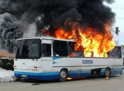 lángol egy busz az autópályán, teljes útzár,tűzoltók két vízsugárral oltják a lángokat