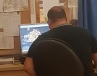 A számítógépen játszik a sürgősségi osztályon ez a recepciós, miközben az emberek a 40 fokban várakoznak a sorban