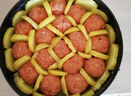 A darált húsból golyókat formált, tortaformába tette, majd körberakta burgonyával, csodás finomság lett!