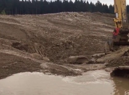 A kotrógép kezelője mozgást észlel a gép előtt, a sárban: nagyon rossz előérzete támad,nézd mit kotor ki a sáros földből!