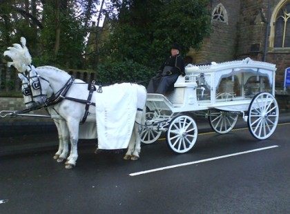 Hófehér hintón húzza a nyitott koporsót a két fehér ló.. Végső nyugalomra helyezik a 14 éves kislányt, akit elütött egy kamionos..