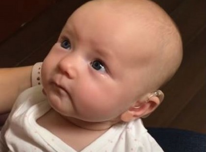 A hallássérült baba életében először hallja anyukája hangját, ahogy azt mondja neki, 